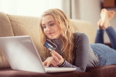 Güzel genç kız kanepe de online satın alma kredi kartı tutan