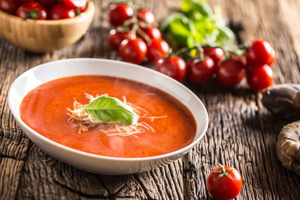 Sopa de tomate quente queijo parmesão e manjericão licença na mesa de aveia velha — Fotografia de Stock