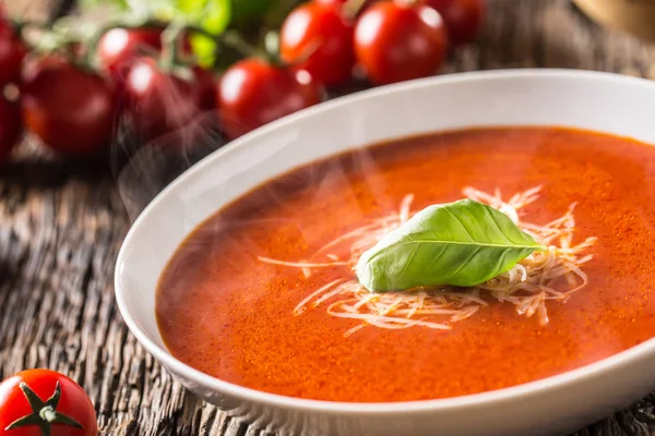 Sopa de tomate quente queijo parmesão e manjericão licença na mesa de aveia velha — Fotografia de Stock