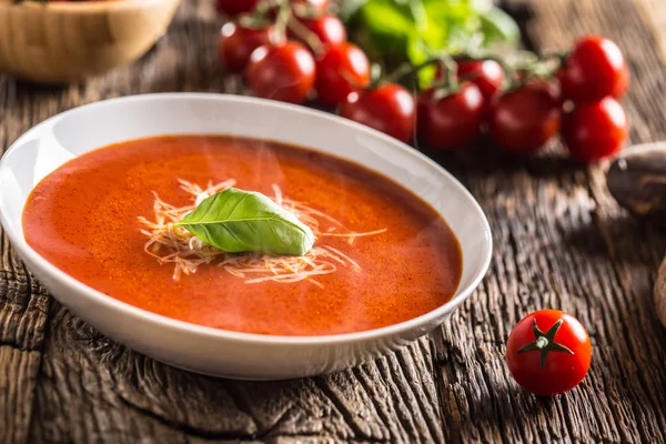 Sopa de tomate quente queijo parmesão e manjericão licença na mesa de aveia velha — Fotografia de Stock