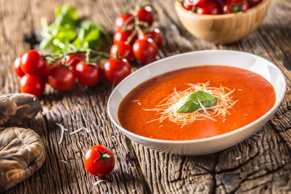 Sopa de tomate quente queijo parmesão e manjericão licença na mesa de aveia velha — Fotografia de Stock