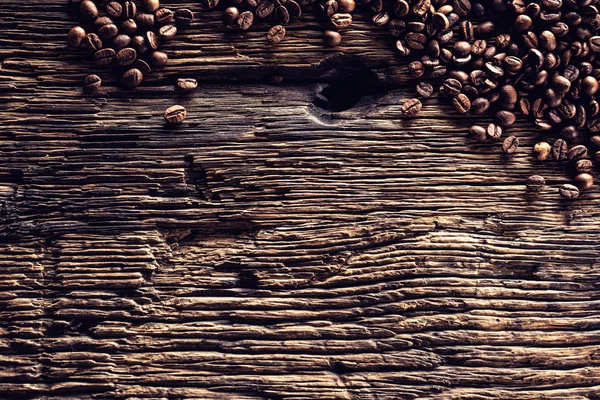 Topp med utsikt kaffebönor på rustik ek bord — Stockfoto