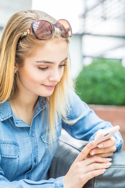 Dziewczyna tekstylny na inteligentny telefon w centrum shpping siedzi w int — Zdjęcie stockowe