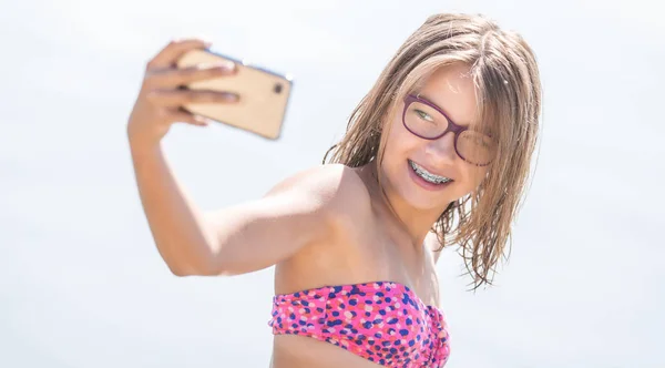 Счастливая девушка с зубным мозгом делает селфи на пляже в США — стоковое фото