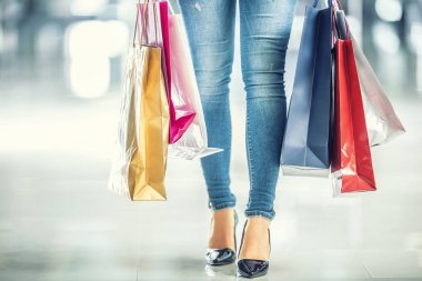 Bir alışveriş kadın ve onu elinde renkli alışveriş çantaları 