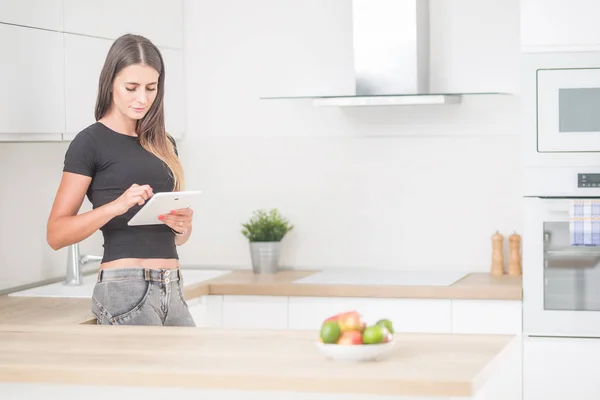 Giovane donna in casa cucina con tablet . — Foto Stock