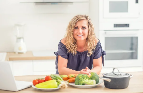 Retrato de mujer adulta feliz en su cocina moderna con olla y —  Fotos de Stock