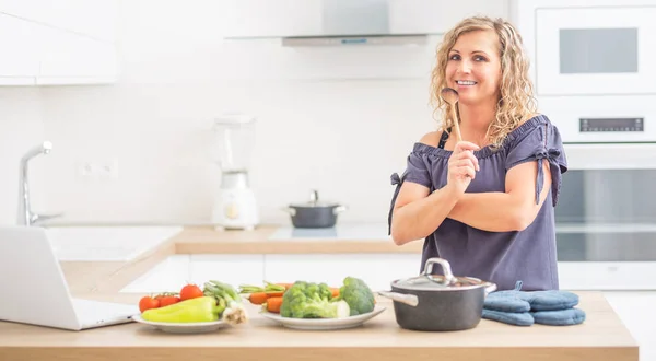 Retrato de mujer adulta feliz en su cocina moderna con olla y —  Fotos de Stock