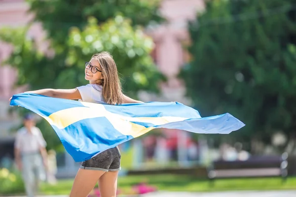 Šťastné dívčí procházky na ulici se švédským praporkem — Stock fotografie