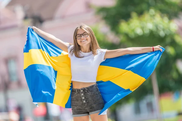 Happy girl touriste marche dans la rue avec drapeau suédois — Photo