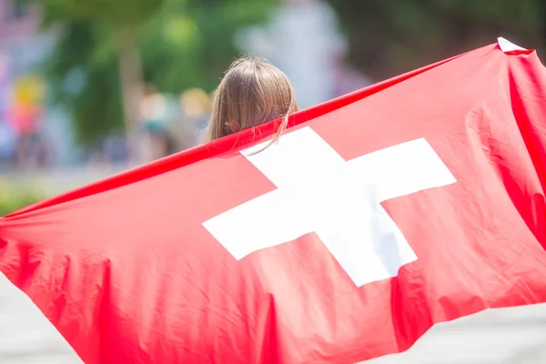 Chica feliz turista caminando en la calle con bandera de Suiza — Foto de Stock