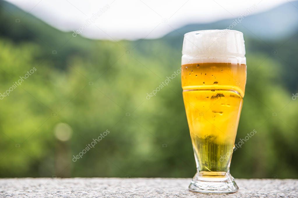 Draft light beer on stone table somwhere in nature