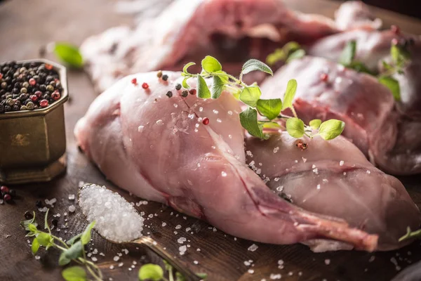 Rohe Kaninchenbeine Salz Pfeffer und Kräuter auf dem Schlachtbrett — Stockfoto