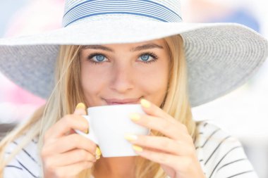 Kafeterinin terasında kahve içen güzel kız. Yaz portrai