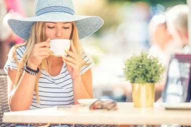 Kafeterinin terasında kahve içen güzel kız. Yaz portrai