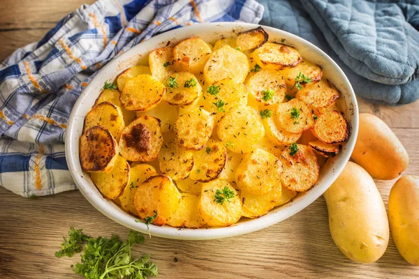 Roasted potatoes with spices and herbs on kitchen table - Top of view — Stock Photo, Image