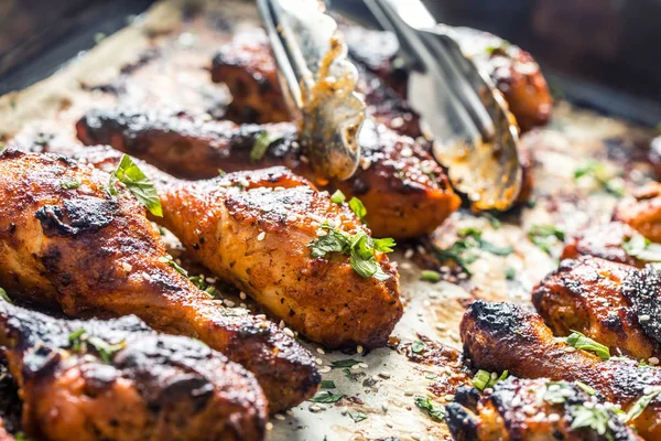 Grilled hicken legs BBQ with spices herbs and sesame on baked paper. Roasted poultry meal in roaster dish — Stock Photo, Image