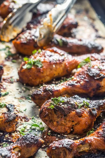 Grilled hicken legs BBQ with spices herbs and sesame on baked paper. Roasted poultry meal in roaster dish — Stock Photo, Image