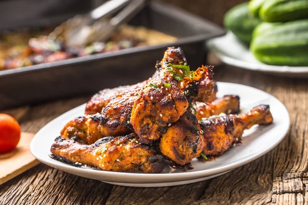 Gegrilde hicken benen BBQ met kruiden kruiden en sesam op gebakken papier. Geroosterd pluimveemeel op witte plaat — Stockfoto