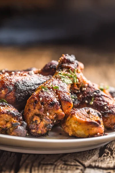 Gegrilde hicken benen BBQ met kruiden kruiden en sesam op gebakken papier. Geroosterd pluimveemeel op witte plaat — Stockfoto