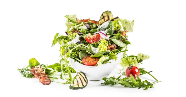 Salade de légumes frais avec tomates au bacon frites olives roquette courgettes vinaigrette tzatziki et huile d'olive isolée sur fond blanc — Photo