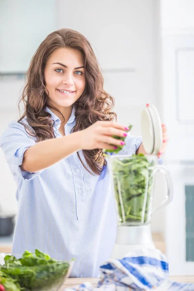 Mulher fazendo sopa de legumes ou smoothies com liquidificador em seu kit — Fotografia de Stock