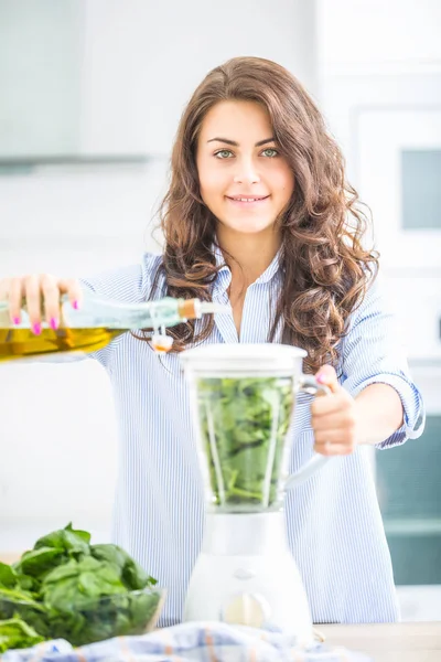 Donna che fa zuppa di verdure o frullati con frullatore nel suo kit — Foto Stock