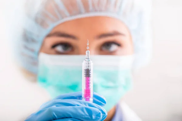 Kvinnlig läkare som arbetar med sprutnål och ampull med medicin — Stockfoto