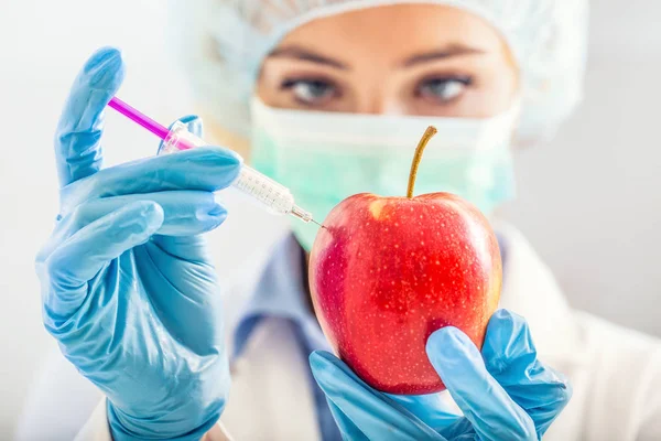 Una mujer bióloga modifica genéticamente una manzana para una vida más larga . — Foto de Stock