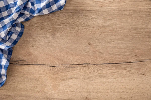 Tovaglia a quadretti blu sul tavolo da cucina in legno . — Foto Stock