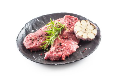 Sığır meeat Rib-Eye biftek zekâ biberiye tuz ve biberiye siyah tabak beyaz izole