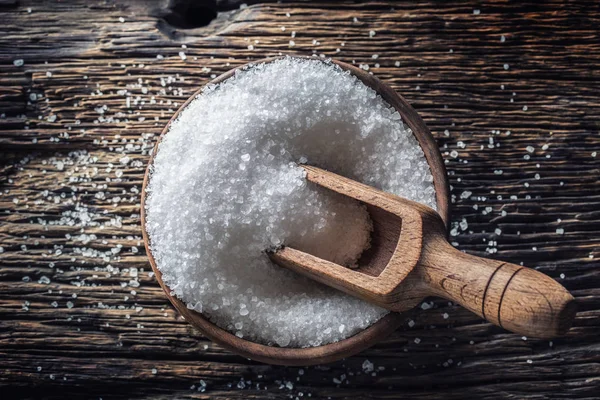 Grovkornigt salt i en träskål med en slev på ett gammalt ek bord — Stockfoto