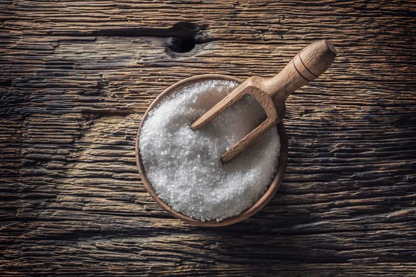 Grovkornigt salt i en träskål med en slev på ett gammalt ek bord — Stockfoto