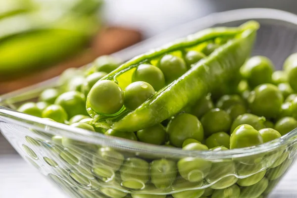 Semillas de guisante verde fresco en cuenco en mesa de cocina — Foto de Stock