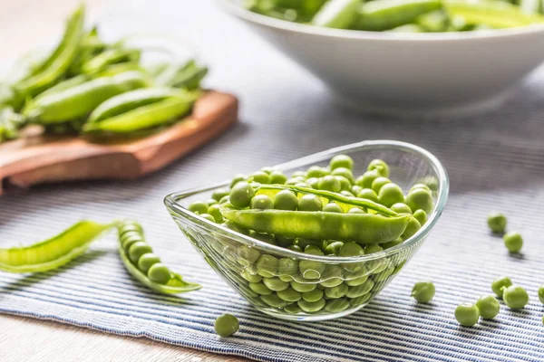 Semillas de guisante verde fresco en cuenco en mesa de cocina — Foto de Stock