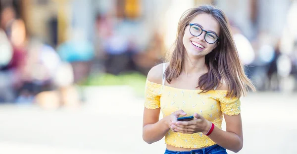 Genç öğrenci kız akıllı telefonuyla mesaj atıp gülümsüyor — Stok fotoğraf