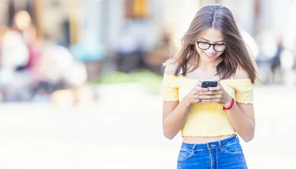 Genç öğrenci kız akıllı telefonuyla mesaj atıp gülümsüyor — Stok fotoğraf