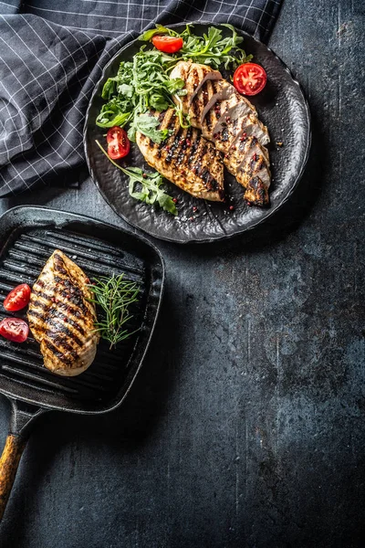 Kipfilet gegrild met specerijen peper zout tomaten rozemarijn en rucola-top uitzicht — Stockfoto