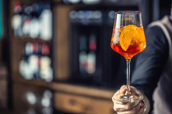 Аперол брызгает. Бармен держит стакан с напитком Aperol Spritz — стоковое фото