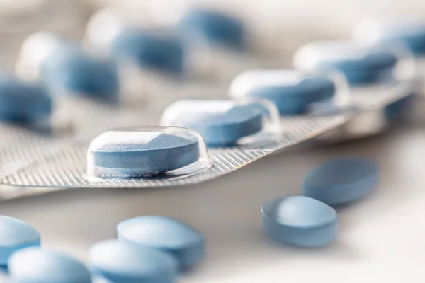 Modré pilulky volné ležící na bílém izolovaném pozadí — Stock fotografie