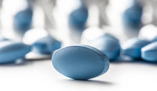 Pílulas azuis soltas deitado em um fundo isolado branco — Fotografia de Stock