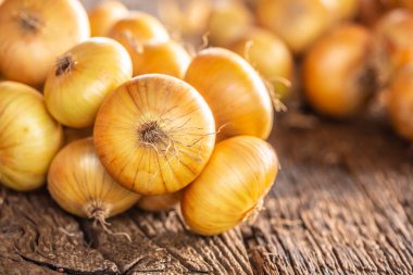 ahşap bir masa üzerinde serbestçe yatan kurutulmuş soğan demeti