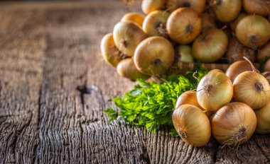 ahşap bir masa üzerinde serbestçe yatan kurutulmuş soğan demeti