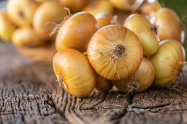 ahşap bir masa üzerinde serbestçe yatan kurutulmuş soğan demeti