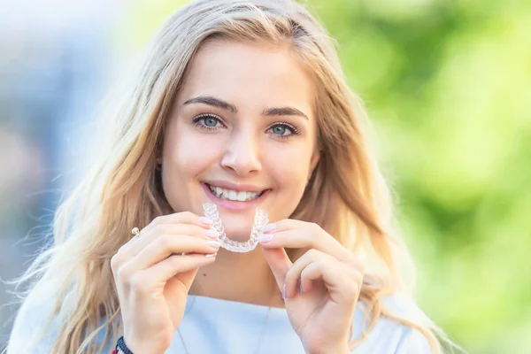 Invisalign ortodonti kavramı - Genç çekici kadın holding