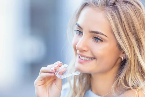 Invisalign ortodonti kavramı - Genç çekici kadın holding