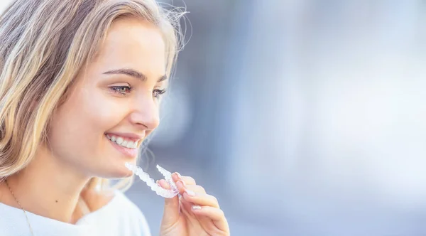 Invisalign ortodonti kavramı - Genç çekici kadın holding