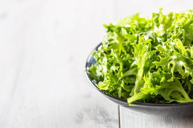 Ahşap masada siyah kase taze salata endivia