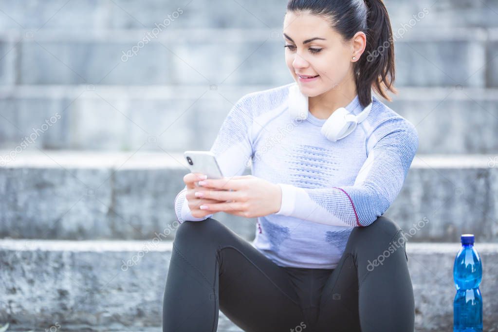 Young woman after training checks sport tracker. Fitness concept