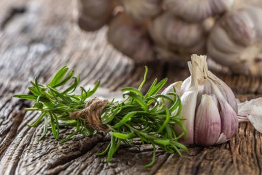 Sarımsak karanfil ve eski ahşap masada taze biberiye ile ampul